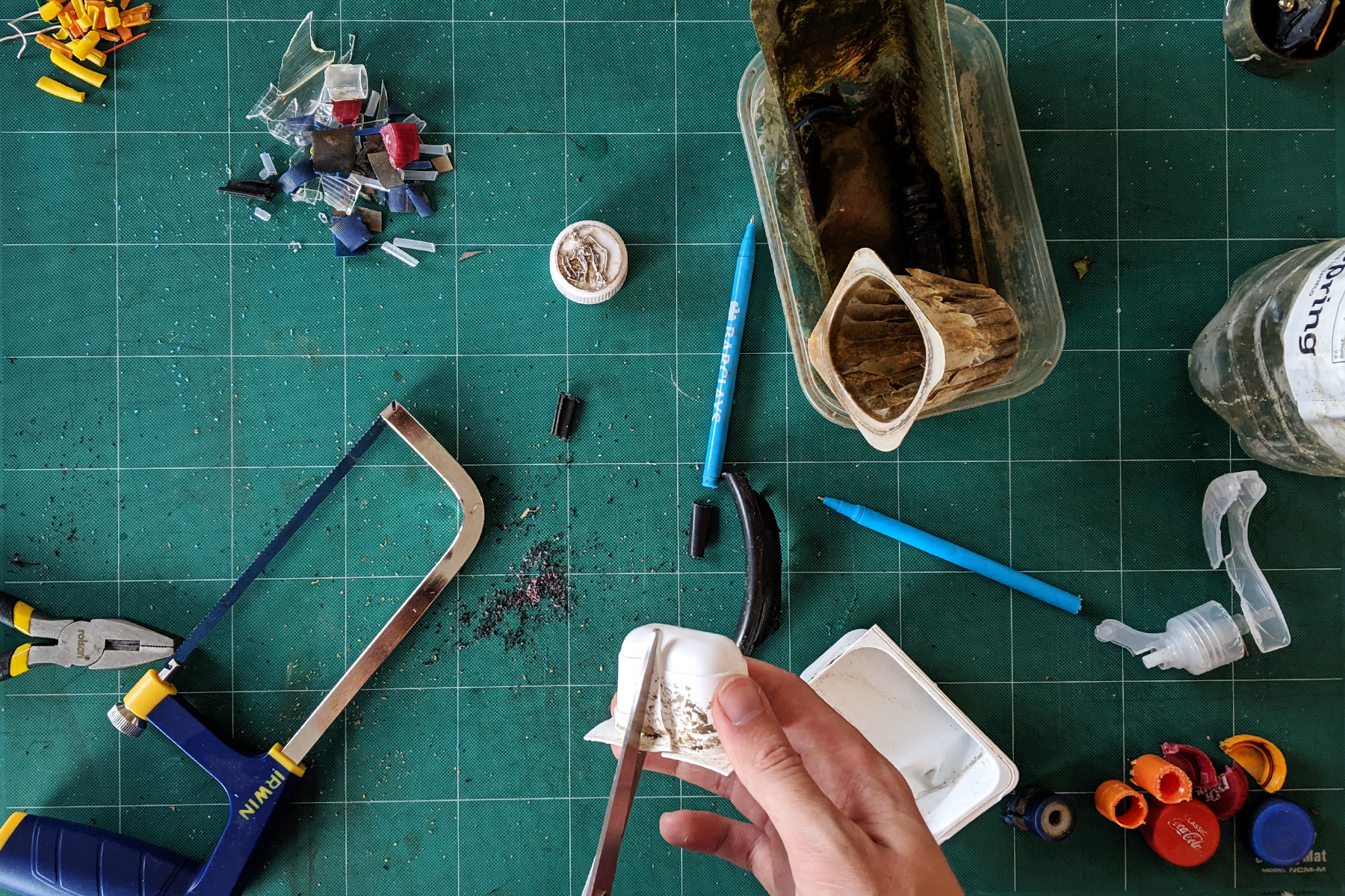 cutting up plastic litter collected from the river in truro to make recycled plastic ecotrophies