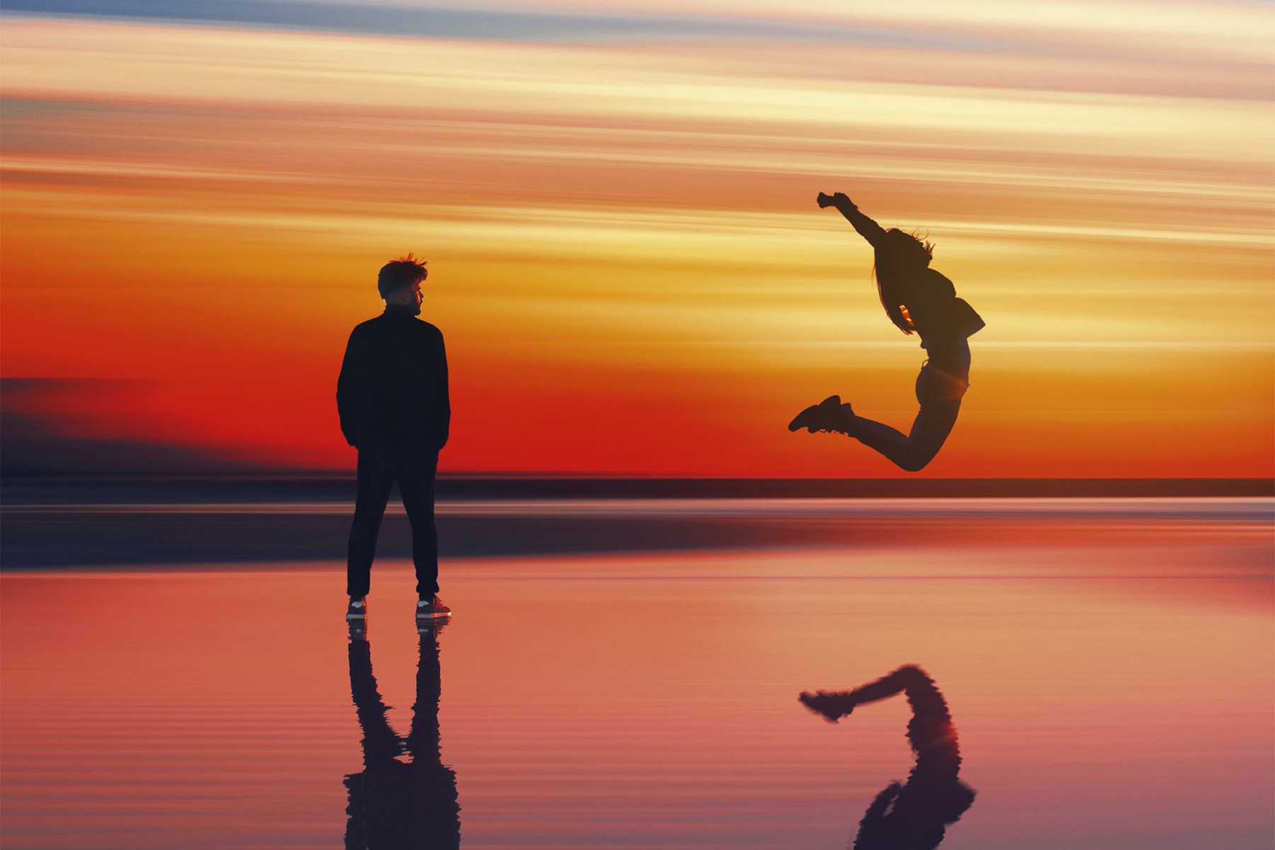 escape 100 winner image of a couple jumping on the beach at sunset