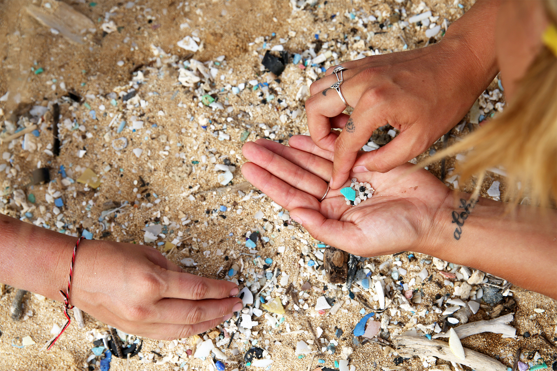 collecting plastic nurdles on the beach, photographed by Eleanor Church Lark Rise Pictures