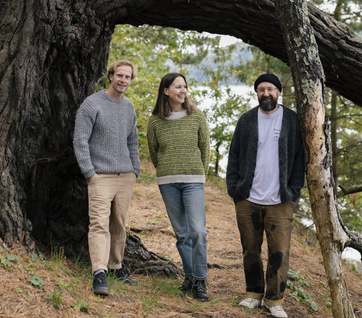 Simon, Helen and Nathan stood in front of a large pine tree