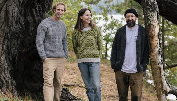 Simon, Helen and Nathan stood in front of a large pine tree
