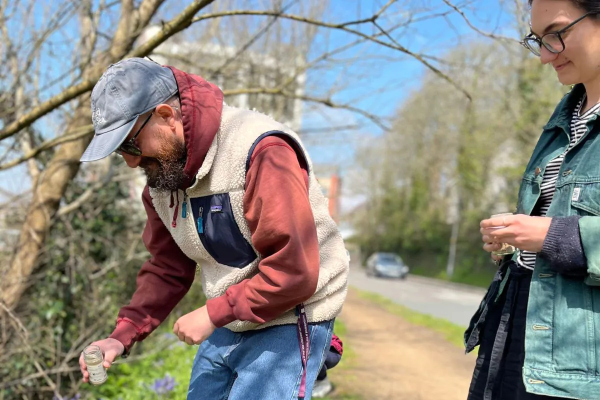 Earth Day seed bombing walk. Two of the Leap team scattering seeds next to road